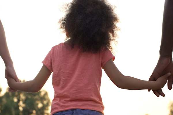 Kid holding hand of parents