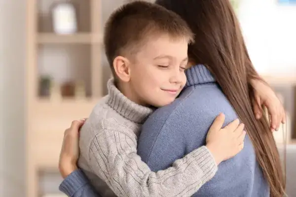Foster child hugging his foster to adopt mom