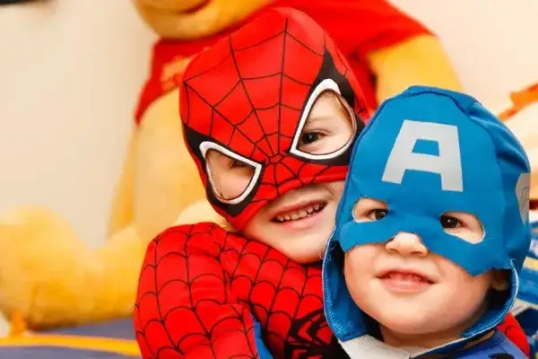 Two young kids dressed in super-hero costumes (Spiderman and Captain America)