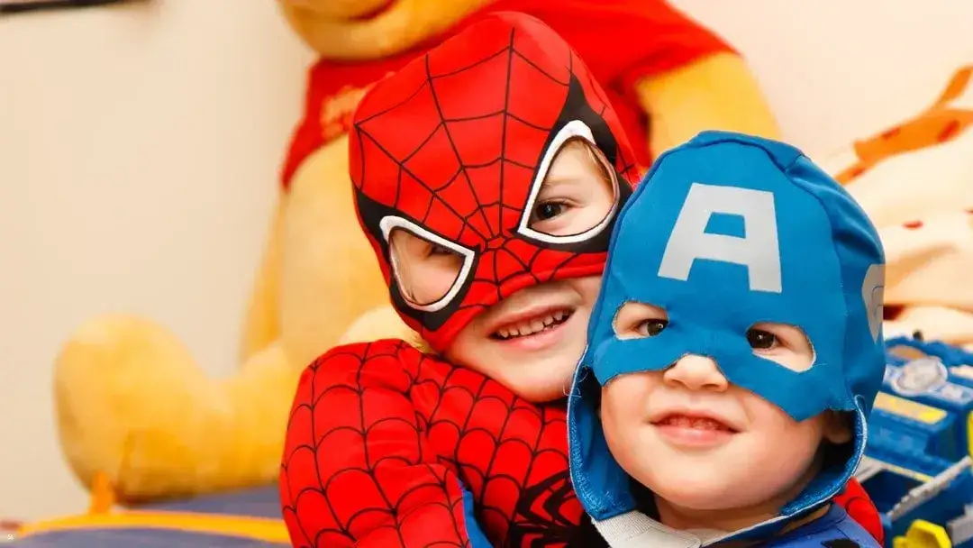 Two young kids dressed in super-hero costumes (Spiderman and Captain America)